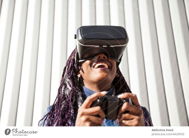Black woman playing VR game vr headset controller experience excited virtual reality goggles young african american black female ethnic afro enjoy amazed