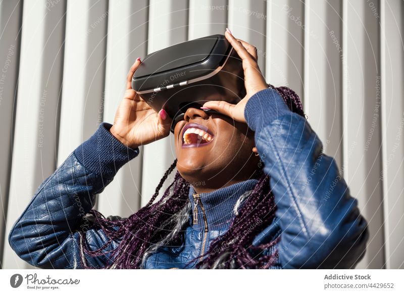 Black woman playing VR game vr headset experience excited virtual reality goggles young african american black female ethnic afro enjoy amazed gamepad joystick