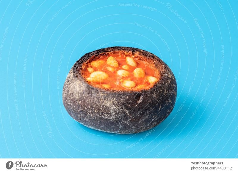 Bread bowl filled with baked beans on a blue table. background black boiled bread breakfast british brown cooked copy space crust cuisine cut out delicious dish