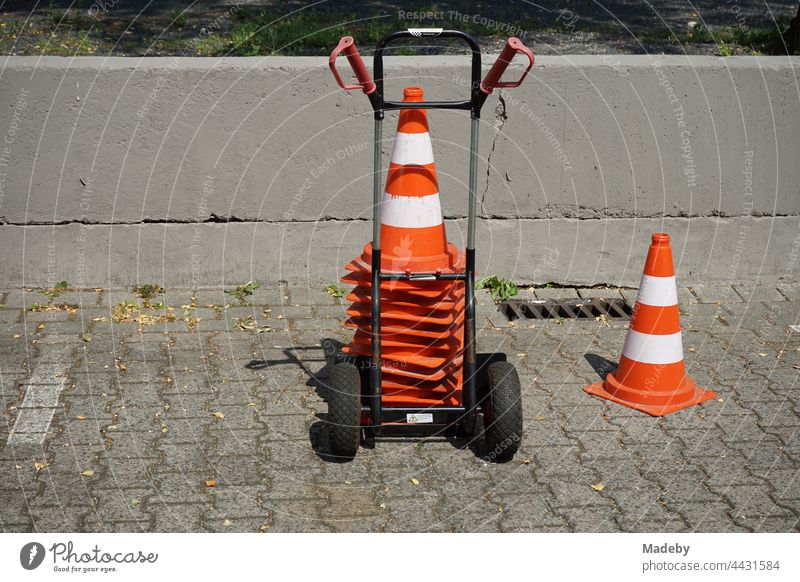 Stacked Lübeck hats on a hand truck on the grey composite pavement of the Klassikstadt parking lot in summer sunshine in the Fechenheim district of Frankfurt am Main in Hesse, Germany