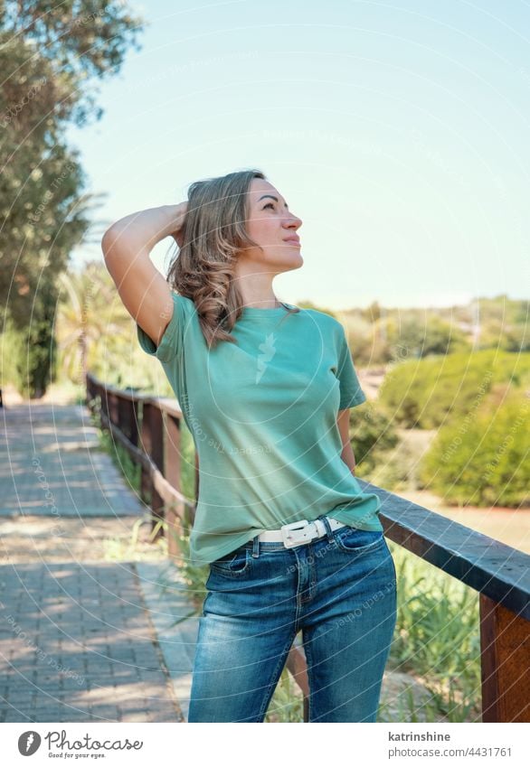 Women wearing t-shirt and jeans stays outdoor in the park - a Royalty Free  Stock Photo from Photocase