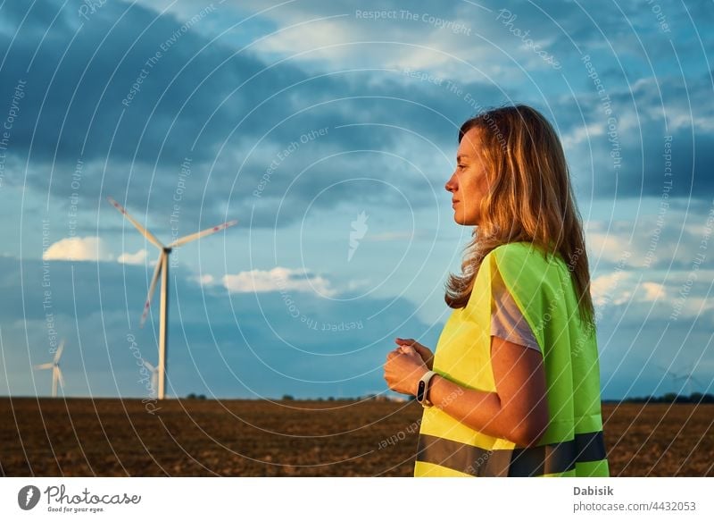 Engineer looks at wind turbine in the field windmill generator energy engineer technology sustainable landscape renewable ecology propeller electric concept