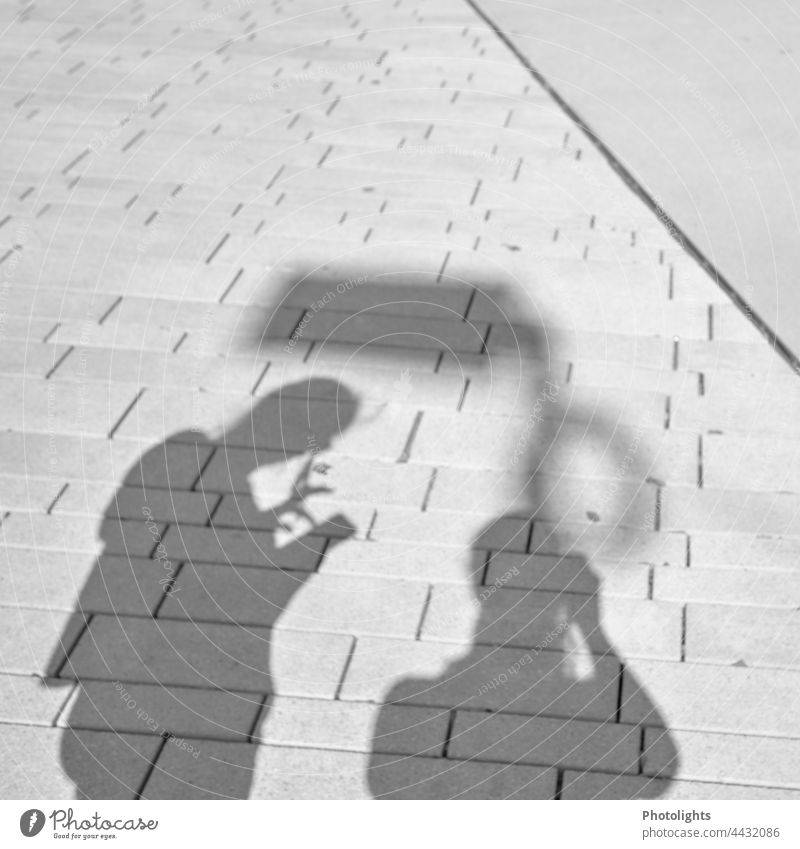 Shadow play 2 persons Contrast Human being smartphone at the same time Street Town pavement Ground Exterior shot people Silhouette in common To go for a walk