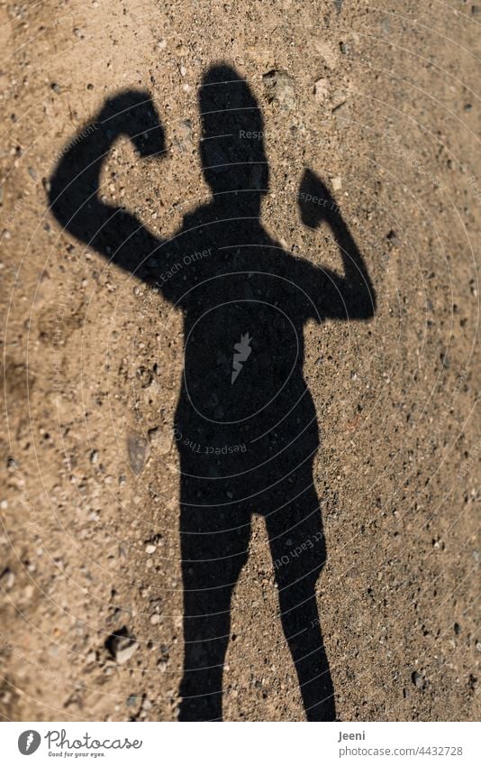 A shadow figure does strength exercises Human being person Child Boy (child) Shadow shadow cast Youth (Young adults) Force flaunt pose vigorously Muscular Body