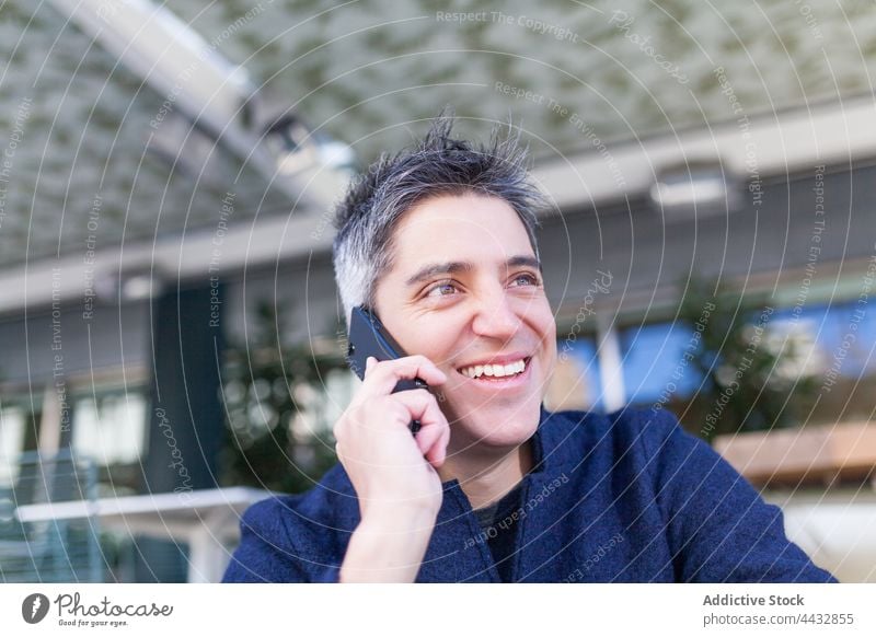 Cheerful man talking on cellphone smartphone male speak smile conversation cheerful mobile happy call phone call gadget street device communicate connection