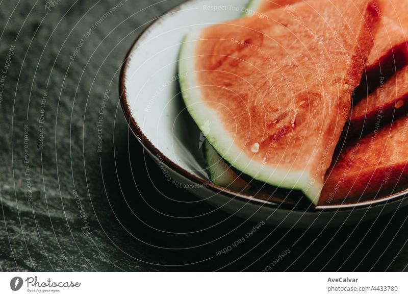 Close up of a dish filled with watermelon over a black marble table, fresh food, wellness, healthy food artist cherry fruits tasty healthy lifestyle juicy