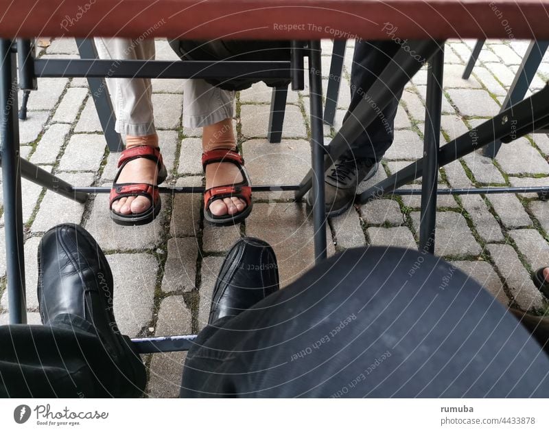 Was passiert unter dem Tisch? unterm Tisch unter den Tisch kehren Beine Füße Tischgestell Kopfsteinpflaster verborgen im Verborgenem Essen Trinken Außen