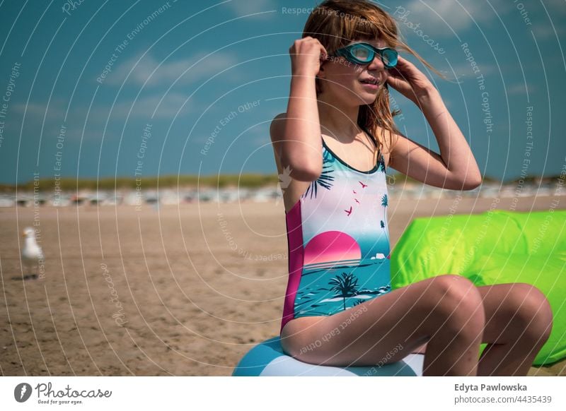 Girl on the beach wearing water goggles protection ocean sea sun portrait kid holiday happiness cute playing holidays Netherlands sky healthy beautiful female