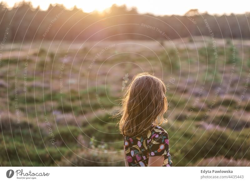 Little girl on a meadow full of heather at sunset grass field rural countryside adventure Wilderness wild
hair vacation travel active summertime day freedom
