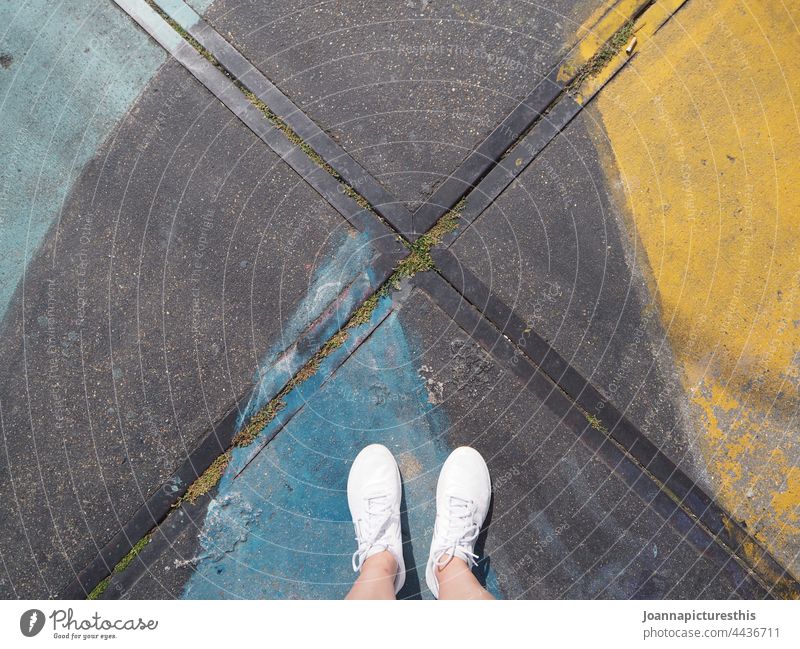 White sneakers shoes white feet legs ground pavement colorful graffiti street art urban