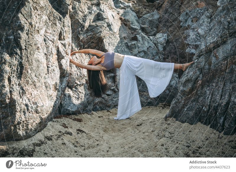 Asian woman practicing yoga with raised leg in mountains backbend leg raised balance flexible stretch arms raised grace highland energy wellness vitality slim