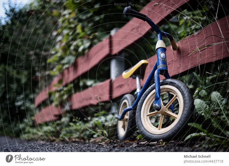 Old wheel on the fence impeller Child Infancy Exterior shot Movement Toddler Bicycle Playing Former Past Review Longing melancholically melancholy Meditative
