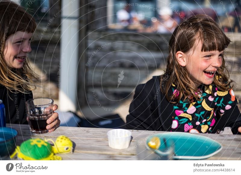 Children having fun in a beach cafe real people authentic laughing funny sweet sugar delicious eating food drink glass friendship together vacation adventure