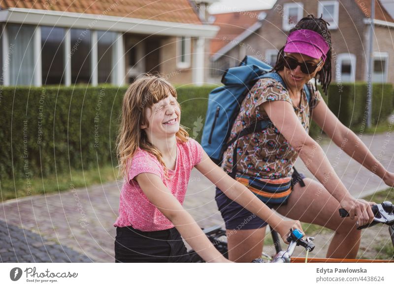 Girl with her mother on bicycles real people authentic parent smile smiling expression love family daughter Dutch Holland Netherlands bike cycling riding