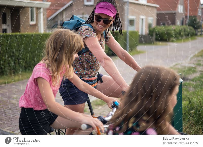 Mum with her children on bikes real people authentic parent smile smiling expression love family mother daughter Dutch Holland Netherlands cycling riding