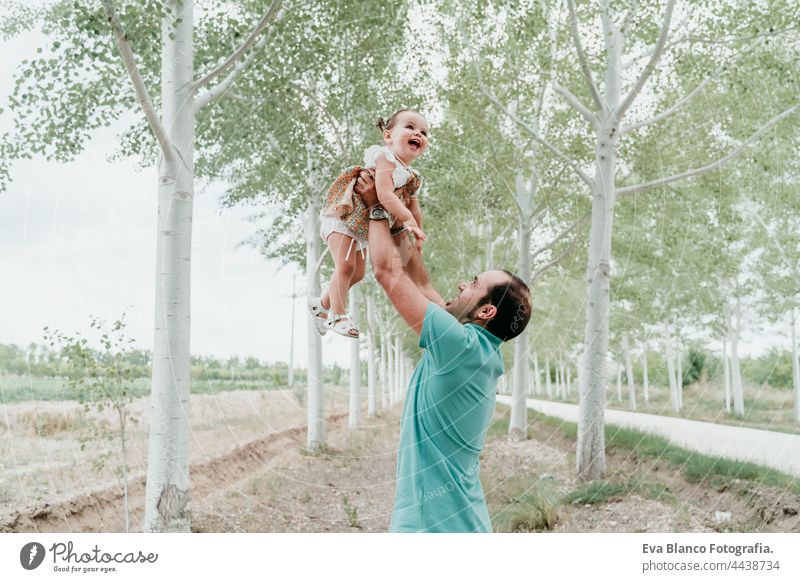 happy father and daughter playing outdoors in path trees. Family, fun and nature concept baby girl forest love together togetherness fathers day lifting up