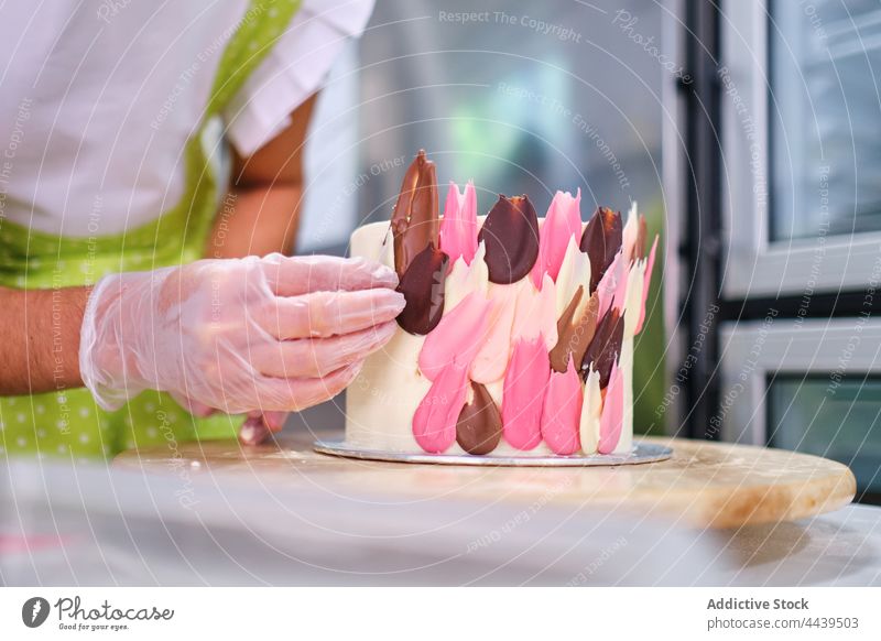 Confectioner in gloves decorating cake with colorful chocolate woman dessert delicious pastry confectionery style decorate sweet female cook tasty food treat