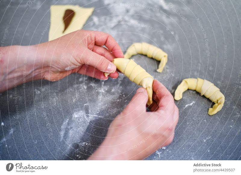 Baker preparing small croissants with chocolate person baker confectionery kitchen table food cook dessert sweet prepare homemade culinary pastry cuisine