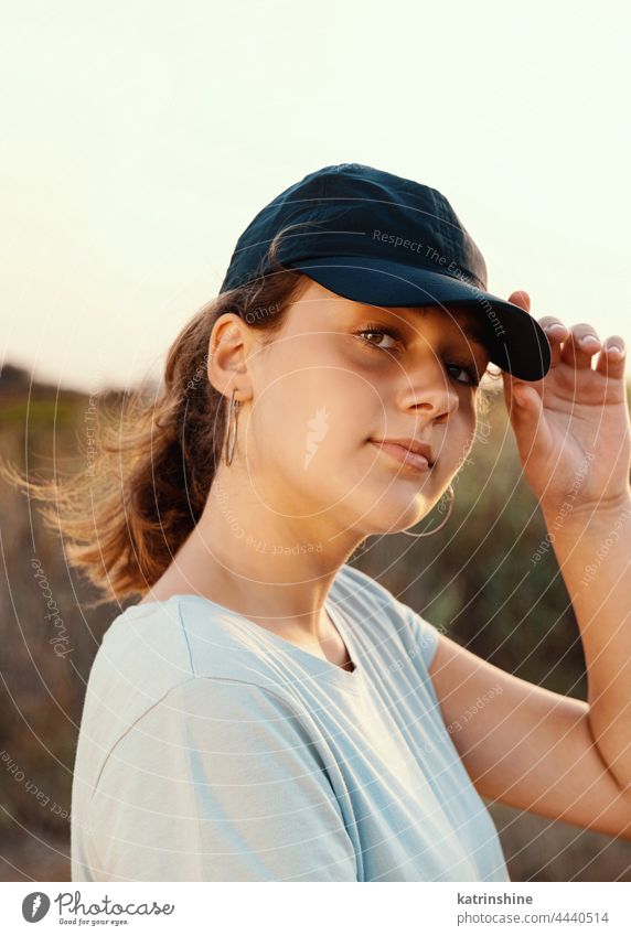 Teen girl in dark blue baseball cap and t-shirt outdoor teenager adolescent countryside filed Caucasian mockup visor wearing t-shirts teen girl childhood female