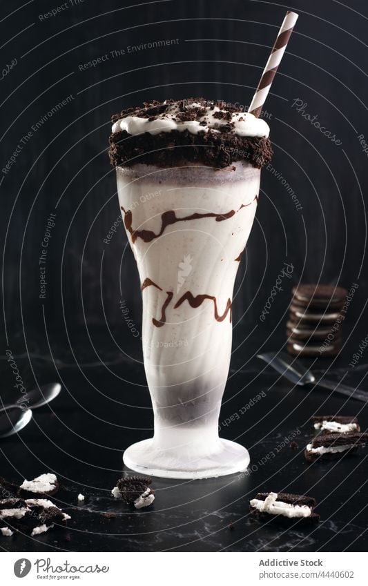 Glass of delicious shake with crushed cookies milkshake chocolate dessert drink beverage sweet flavor glass straw creative design ice cream dairy product