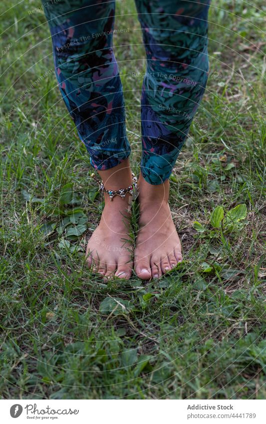 Barefoot woman standing on green grass in park nature barefoot harmony calm tranquil young natural female environment daylight accessory lady practice peaceful