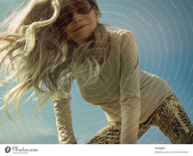 A blonde woman with sunglasses looks at the camera Woman Outdoors Summer Femininity Attractive long hair portraite look down Dynamic slender woman Slim
