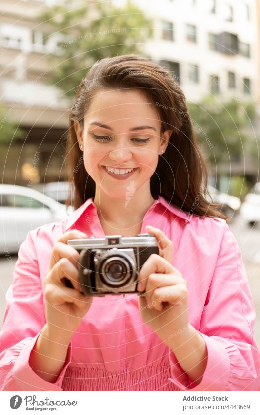 Young smiling woman taking photo on vintage camera take photo photo camera moment classic capture focus lens retro female memory building street long hair