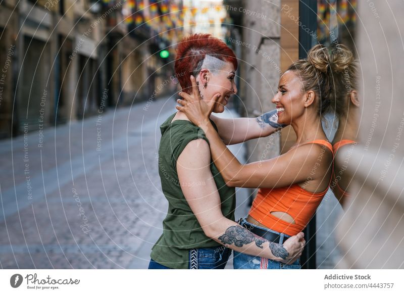 Cool happy homosexual girlfriends in moment of kiss on the street couple embrace relationship leaning cheerful love tattoo lgbt women delight pavement dreamy
