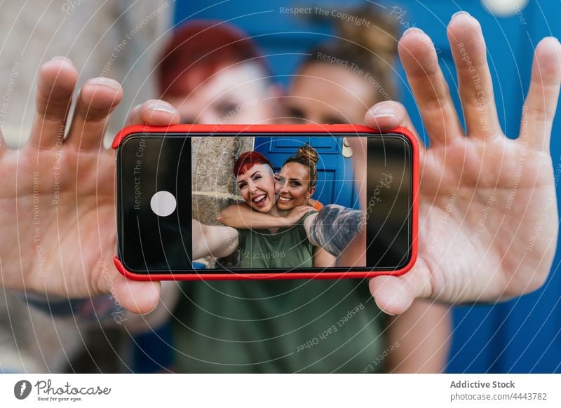 Happy lesbian couple taking selfie on smartphone self portrait having fun cool moment cheerful using gadget women same sex girlfriend spend time happy