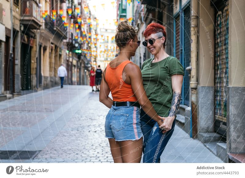 Cool happy homosexual girlfriends in moment of kiss on street couple embrace relationship love tattoo lgbt women pavement mindfulness amorous trendy mohawk