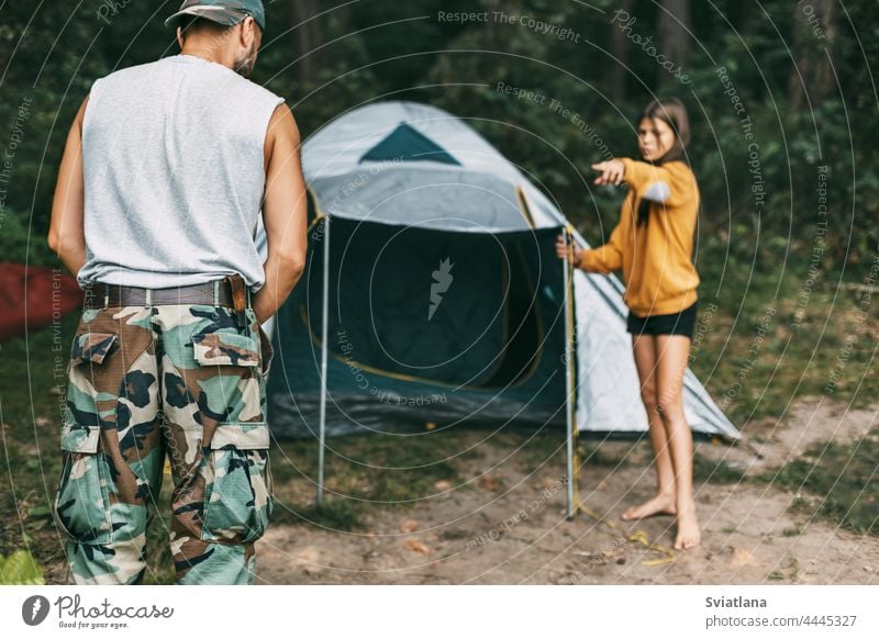 A happy father and daughter are setting up a camping tent. Family time, family rest, care installing little male parent parenthood parenting hiking relationship