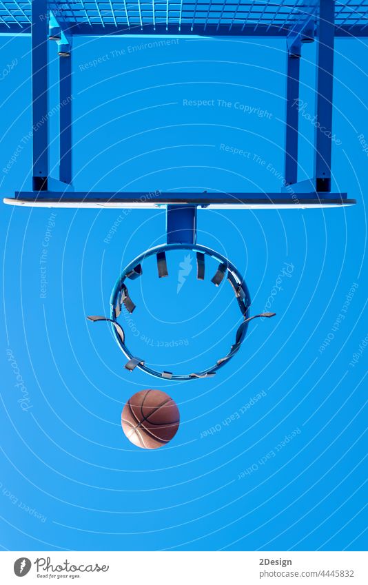 Street basketball ball falling into the hoop. action ambition community competition court game goal net outside play recreation score success triumph win youth