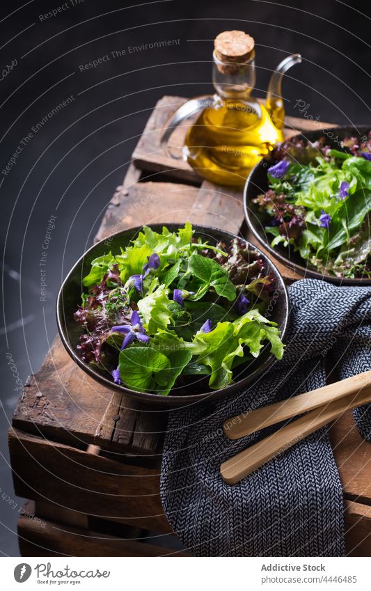 Delicious lettuce and wildflower salad in bowls on dark background healthy food vegetarian vegetable natural fresh oil delicious vitamin nutrient leaf portion