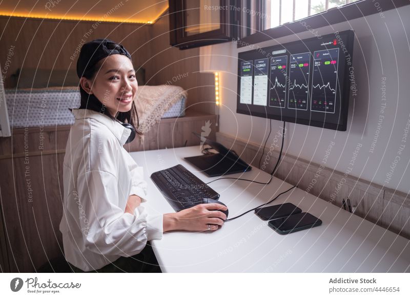 Ethnic smiling female trader analyzing cryptocurrency market statistics woman analyze data using cheerful happy smile monitor diagram delight workplace finance