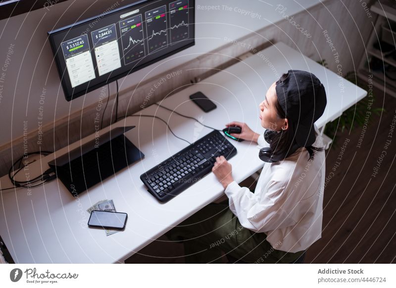 Serious ethnic female trader analyzing cryptocurrency market statistics woman analyze data using monitor diagram workplace finance internet busy economy