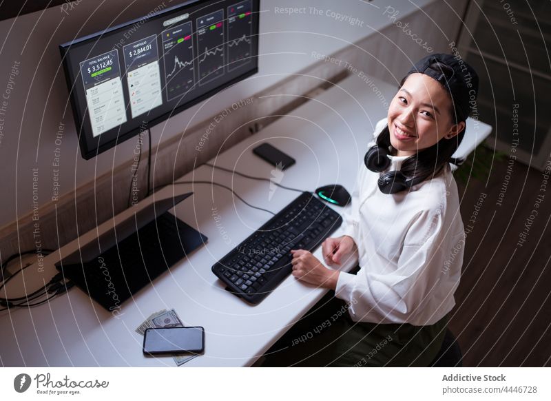 Ethnic female trader analyzing cryptocurrency market statistics woman analyze data using cheerful happy smile monitor diagram delight workplace finance internet