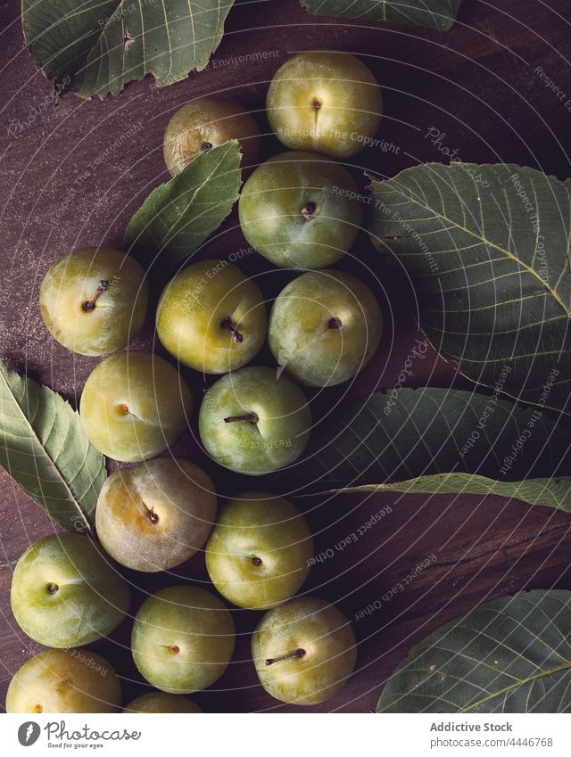 Fresh green plums placed on wooden table fresh vitamin organic healthy food leaf natural fruit plant delicious nutrition raw yummy edible season nutrient