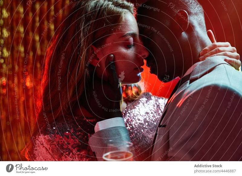 Crop romantic multiracial couple with champagne during New Years Eve moment kiss relationship love party new year ray portrait amour eve celebrate romance style