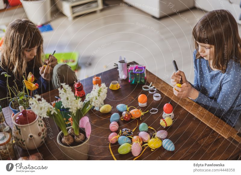Two girls painting Easter eggs at home indoor decorating art preparation decoration hobby handcraft colored easter egg festive hunt celebrate seasonal holiday