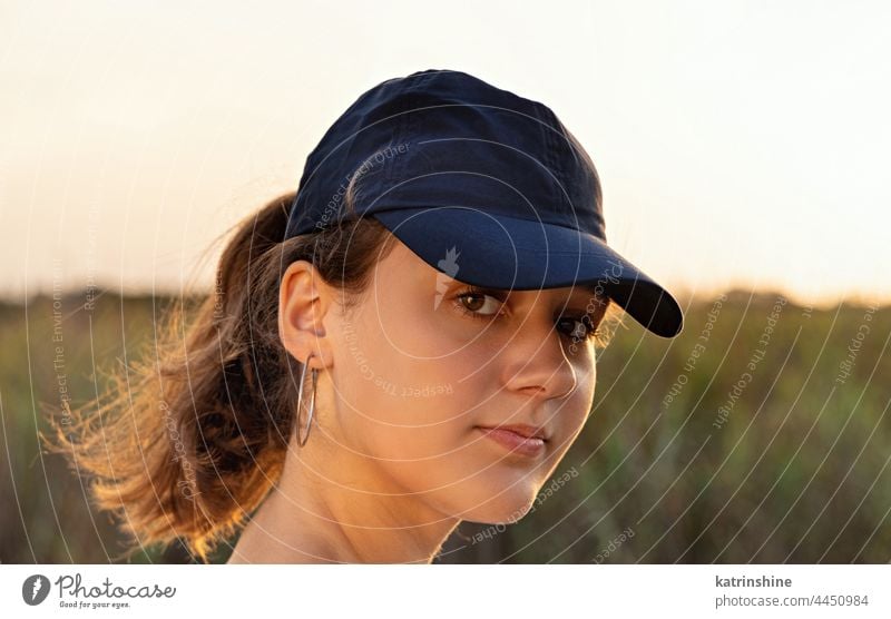 Teen girl in dark blue baseball cap at sunset outdoor teenager adolescent Caucasian mockup visor head wearing teen girl looking stright childhood female