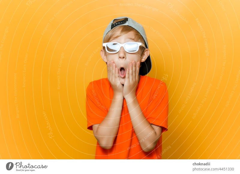 a child in glasses for watching movies opened his mouth in surprise and holds his cheeks with his hands boy sunglasses fashion face person people beauty 3d