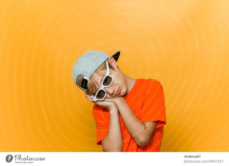a child in a cap and glasses for watching movies has folded his hands near his head and is sleeping boy sunglasses fashion face person people beauty 3d