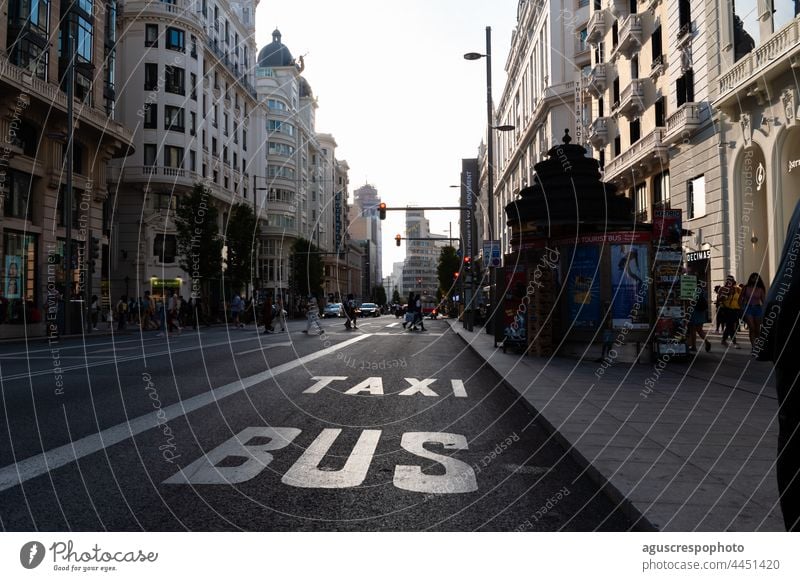 View of Gran Via street in the center of Madrid at dawn in the foreground the bus and taxilanes. spain September 5th people walking sunlight day downtown europa