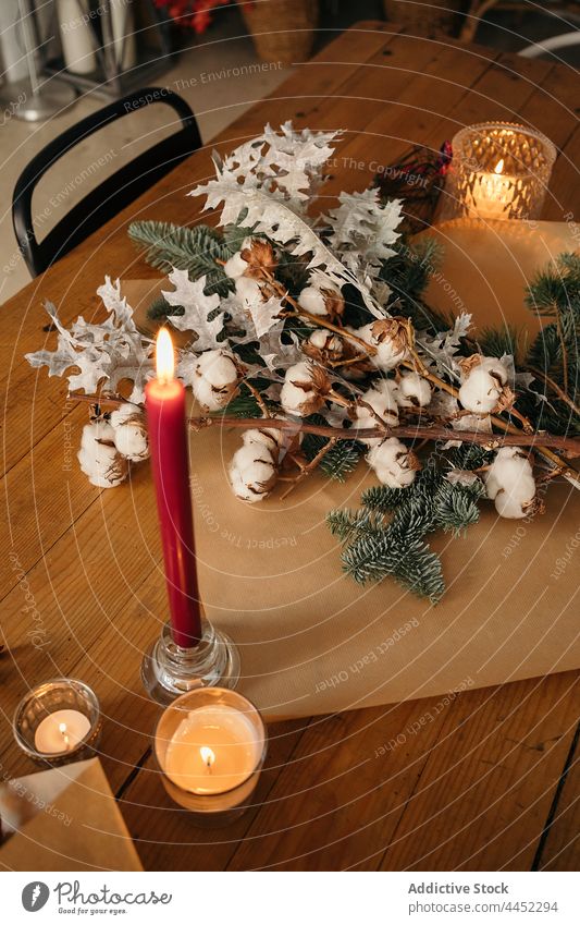 Stylish Christmas bouquet placed on wooden table candle decor christmas branch festive cotton fir decoration xmas design event celebrate composition style burn