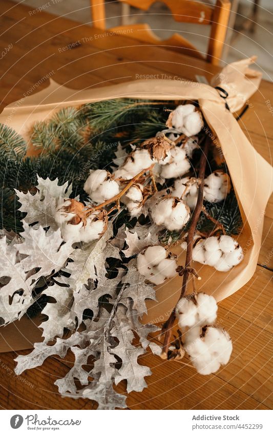 Stylish Christmas bouquet placed on wooden table decor christmas branch festive cotton fir decoration xmas design event celebrate composition style burn room