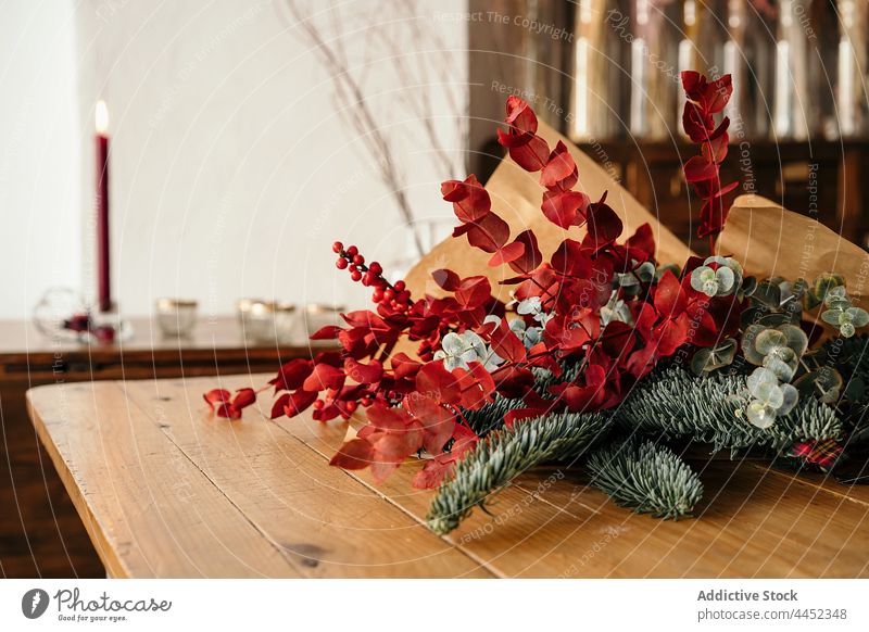 Stylish Christmas bouquet placed on wooden table decor christmas branch festive twig berry holly decoration xmas design event celebrate composition style burn