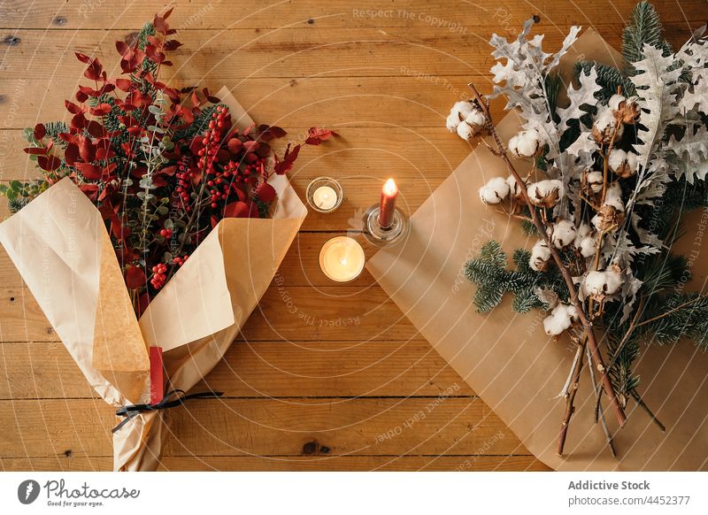 Stylish Christmas bouquet placed on wooden table candle decor christmas branch festive cotton fir decoration xmas design event celebrate composition style burn