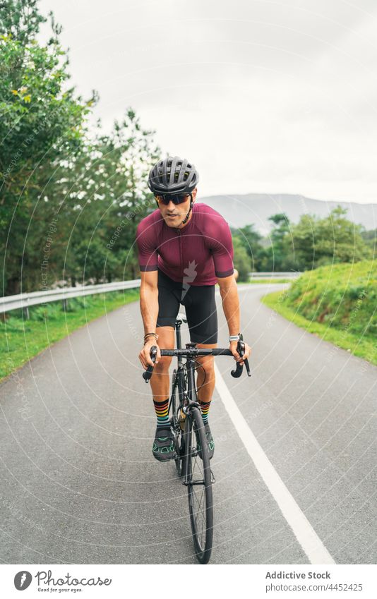 Bicyclist riding bike during training on countryside road bicyclist ride sport racing bicycle cycling workout activity man route direction road bicycle