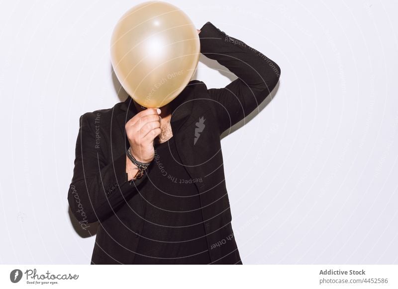 Man covering face with balloon at party man event hide holiday celebrate occasion surprise cover face male studio shot congratulate incognito decoration