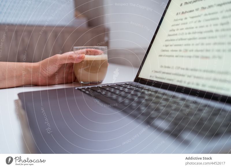 Anonymous writer with laptop and coffee at home freelance desk woman portrait using gadget text blogger author device netbook monitor black screen internet